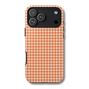 Può includere: Custodia per telefono con motivo a quadretti arancione e bianco con modulo fotocamera nero. La custodia ha una finitura liscia e un design protettivo. La custodia è progettata per uno smartphone.