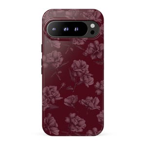 May include: A dark burgundy smartphone case featuring a repeating pattern of sketched flowers in a lighter shade of maroon. The case has a horizontal camera cutout at the top with three circular lenses and a flash, matching the phone's design.