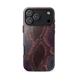 Puede incluir: Una funda para smartphone con un patrón de piel de serpiente texturizado en tonos morado oscuro, magenta y negro. La funda tiene un recorte rectangular en la parte superior para un sistema de triple cámara y un flash, con botones laterales negros.