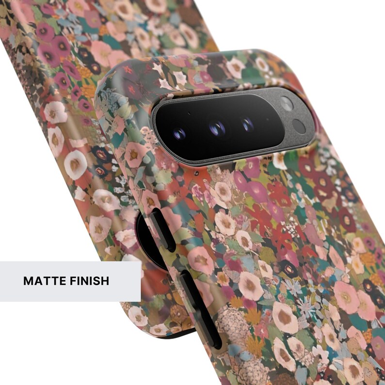 May include: A protective phone case featuring a dense, colorful floral pattern with shades of pink, deep red, dark green, and cream. The case has a matte finish and includes precise cutouts for the camera module and side buttons on the device.