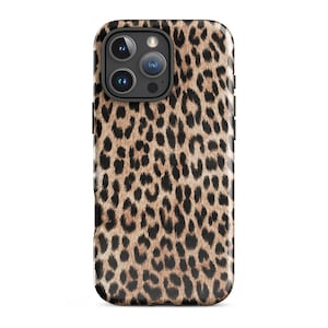 May include: A smartphone case with a leopard print design. The case features a pattern of brown and black spots on a tan background. The phone case has a black camera module with three lenses.