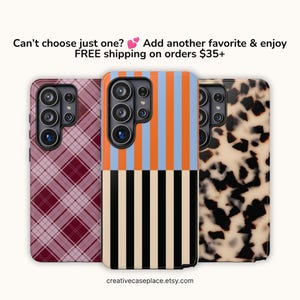 May include: Three smartphone cases featuring distinct patterns: a maroon and white plaid design, a vertical orange and light blue stripe top half with black and cream vertical stripes on the bottom, and a cream and black tortoiseshell print.