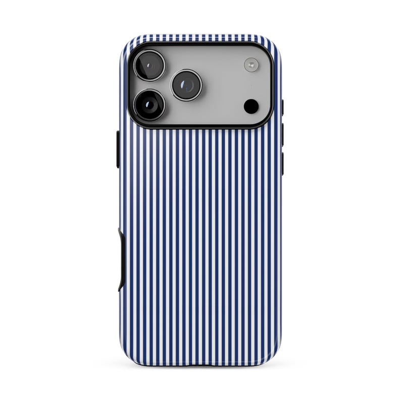 May include: A smartphone case featuring a pattern of thin, vertical navy blue and white stripes. The case has a rectangular camera cutout at the top left, revealing three circular camera lenses and a flash component on the device.