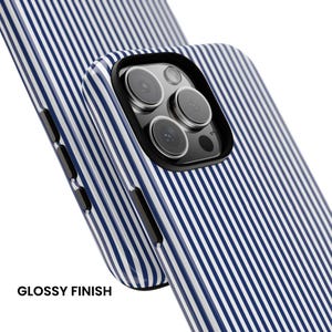 May include: A smartphone case with a glossy finish featuring a pattern of thin vertical navy blue and white stripes. The case includes a black camera cutout frame and black side buttons, showcasing the triple lens camera array of the phone.