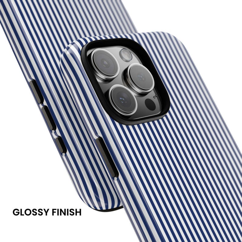 May include: A smartphone case with a glossy finish featuring a pattern of thin vertical navy blue and white stripes. The case includes a black camera cutout frame and black side buttons, showcasing the triple lens camera array of the phone.