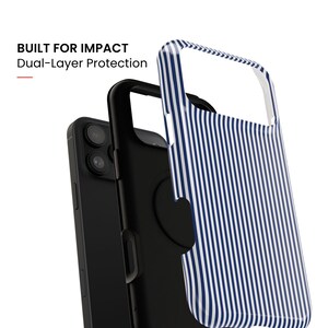 May include: A dual-layer phone case featuring a blue and white vertical striped outer shell and a solid black inner layer, shown with a black smartphone. The text BUILT FOR IMPACT Dual-Layer Protection is visible in the upper left corner.