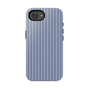 May include: A smartphone case featuring a repeating pattern of thin, vertical navy blue and white stripes. The case has a circular cutout at the top left corner for a camera lens and flash, with black side buttons visible on the edges.