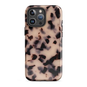 Op de afbeelding: Een smartphonehoesje met een schildpadpatroon. De hoes heeft een beige achtergrond met onregelmatige donkerbruine en zwarte vormen. De hoes heeft een glanzende afwerking en een camera-uitsparing met drie lenzen.