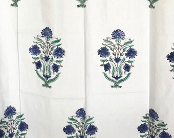 Könnte beinhalten: Weißer Stoff mit einem sich wiederholenden Muster aus blauen Blumensträußen und grünen Blättern. Das florale Design ist gleichmäßig verteilt und erzeugt eine symmetrische Anordnung. Der Stoff scheint leicht zu sein, möglicherweise Leinen oder Baumwolle, geeignet für Vorhänge oder Bettwäsche.