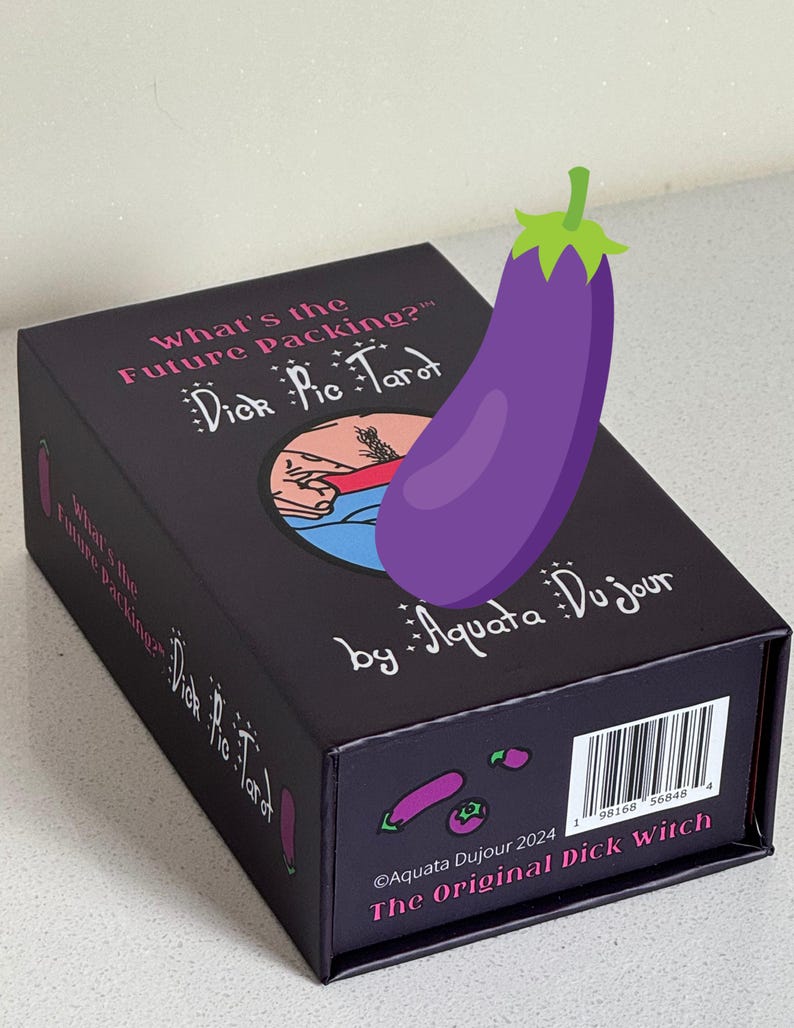 K&ouml;nnte beinhalten: Eine schwarze Schachtel mit "Dick Pic Tarot"-Karten mit dem Text "What's the Future Packing?" und "by Aquata Du jour". Eine lila Aubergine-Grafik ist auf die Schachtel gelegt. Auf der Unterseite der Schachtel steht "The Original Dick Witch."
