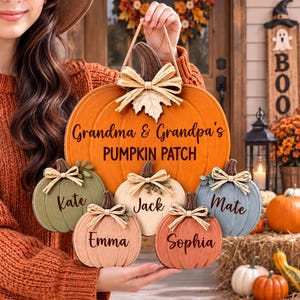 May include: A large orange pumpkin-shaped wooden sign with the text Grandma & Grandpa's PUMPKIN PATCH, featuring five smaller attached pumpkins in green, cream, blue, peach, and orange, each personalized with names Kate, Jack, Mate, Emma, and Sophia.