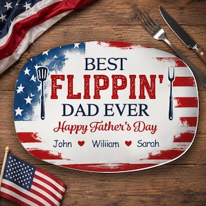 May include: Oval-shaped platter with a patriotic design. The platter features the text "BEST FLIPPIN' DAD EVER Happy Father's Day" in red and blue. Includes names and heart symbols. A spatula and fork are on the sides.