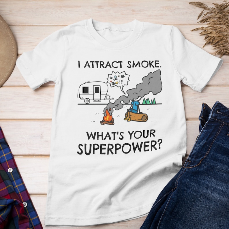 May include: White t-shirt with a funny camping illustration and the text "I attract smoke. What's your superpower?"