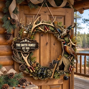 May include: A decorative wreath featuring a deer head, a mallard duck, a pheasant, a tent, binoculars, shotgun shells, and an axe. A wooden sign in the centre displays the text THE SMITH FAMILY EST. 2026, surrounded by pine branches and pinecones.