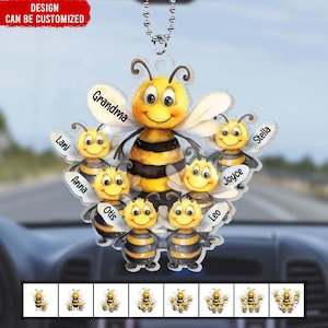 Peut inclure: Un charme de voiture représentant un groupe d'abeilles de dessin animé avec des noms écrits sur chaque abeille. Les noms sont Grand-mère, Lani, Anna, Otis, Léo, Joyce et Stella. Les abeilles sont jaunes et noires avec des yeux bruns et des sourires. Le charme est suspendu à une chaîne argentée.