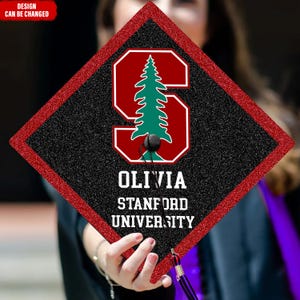 May include: A black and red graduation cap with a white border. The cap has a red "S" with a green pine tree inside, the text "OLIVIA", "STANFORD", and "UNIVERSITY" in white.