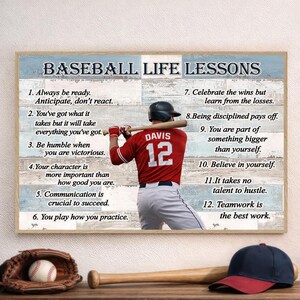 Op de afbeelding: Een ingelijste print met de tekst "BASEBALL LIFE LESSONS" en een honkbalspeler in een rood shirt met nummer 12. De print bevat een honkbalhandschoen, een honkbal, een honkbalknuppel en een honkbalpet.