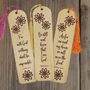 Peut inclure: Trois marque-pages en bois avec des motifs floraux et des citations inspirantes. Chaque marque-page a un pompon de couleur différente : rose, jaune et orange. Le texte comprend "As for me and my house, we will serve the Lord."