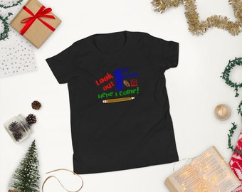 May include: Black youth t-shirt with a graphic design of a blue number one, a red pencil, a brown football, and a red and white checkerboard. The text on the shirt reads "Look out Here I Come!"
