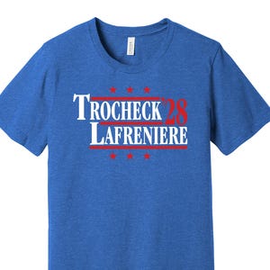 May include: A royal blue t-shirt with a white and red political campaign slogan that reads "Trocheck '28 Lafreniere".