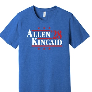 May include: A royal blue t-shirt with a white and red graphic that says "Allen '28 Kincaid" with stars above and below the text.