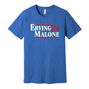 May include: A royal blue t-shirt with a white graphic that reads "Erving '84 Malone" in red and white lettering. The graphic is reminiscent of a political campaign slogan.