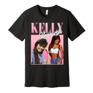 May include: Black t-shirt with a pink and white graphic of Kelly Kapowski from the TV show Saved by the Bell. The graphic features two images of Kelly, one with a white crop top and suspenders, and the other with a blue shirt.