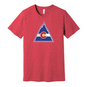 May include: Red t-shirt with a distressed graphic of a mountain range and the Colorado state flag.