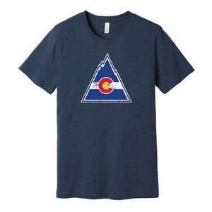 May include: A navy blue t-shirt with a distressed graphic of a mountain range and the Colorado state flag inside a triangle.