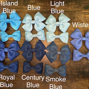 May include: Assortment of blue hair bows in various shades, including Island Blue, Light Blue, Wisteria, Royal Blue, Century Blue, and Smoke Blue.