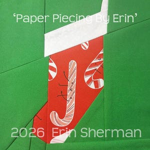 Op de afbeelding: Een stoffen quiltblok met een rode kous met een witte boord tegen een effen groene achtergrond. De kous is versierd met een zuurstokpatroon en de tekst 'Paper Piecing By Erin' en '2026 Erin Sherman' is over de afbeelding heen geplaatst.