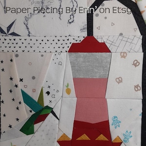 Könnte beinhalten: Ein Patchwork-Quiltblock mit einer roten, rosa und grauen Teekanne mit goldener Verzierung. Der Block ist umgeben von anderen Stoffquadraten mit verschiedenen Mustern, darunter Sterne, Herzen und Bienen. Der Text "Paper Piecing By Erin' on Etsy" und "2024 Erin Sherman" ist auf dem Bild zu sehen.