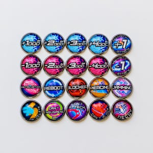 Op de afbeelding: Een verzameling van twintig ronde spel tokens met verschillende ontwerpen en tekst. De tokens hebben een metallic zilveren rand en een glanzend, kleurrijk midden. Tekst omvat "+1000", "-1000", "Retaliation", "Reboot", "Blocker", "Piercing", "Jamming" en "Decoy".