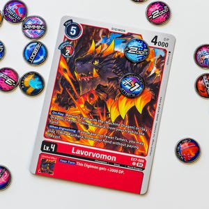 May include: A Digimon trading card featuring Lavorvomon, a fiery dragon-like creature. The card has a red border and includes game text. Surrounding the card are several circular game tokens with various designs and text.