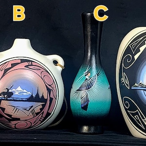 May include: Four handcrafted ceramic vases with Native American designs. The vases feature various shapes and sizes, with painted scenes of landscapes, figures, and geometric patterns in earth tones and vibrant colours. The vases are displayed against a dark background.