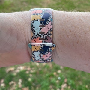 May include: A colourful watch band featuring a pattern of pastel bunnies and a black and white leopard print. The band is made of silicone and has a buckle closure.