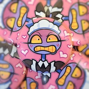 Può includere: Bottone rosa con un personaggio dei cartoni animati in abito da cameriera. Il personaggio ha un viso rosa, occhi gialli e un'espressione severa. Cuori bianchi sono sparsi sullo sfondo rosa. Il personaggio indossa un abito da cameriera bianco e blu.