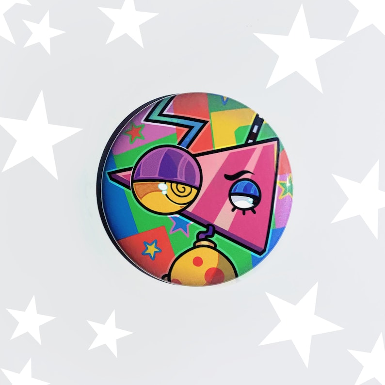May include: A colorful button with a cartoon character with a single eye and a pink triangle shape. The character is wearing a purple hat and has a yellow eye with a spiral inside. The background is a colorful geometric pattern.