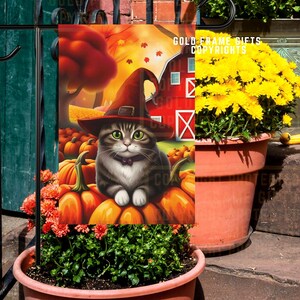 Peut inclure: Un drapeau de jardin d'Halloween avec un chat tigré portant un chapeau de sorcière, assis sur des citrouilles. L'arrière-plan comprend une grange rouge et des feuilles d'automne. Le drapeau est sur un support en métal noir, avec des plantes orange et vertes dans un pot en terre cuite.