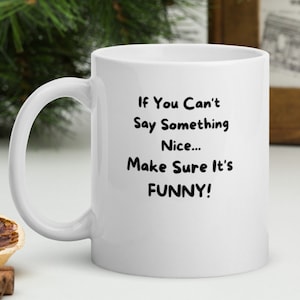 May include: White ceramic coffee mug with a black inscription that reads "If You Can't Say Something Nice... Make Sure It's FUNNY!"