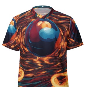 May include: A short-sleeved t-shirt with a colourful abstract design featuring a large, shiny, blue, red and orange sphere in the centre. The background is a swirling pattern of orange, yellow and blue.