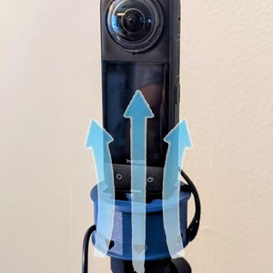 May include: A black 360-degree camera mounted on a blue tripod with a black cord attached. The camera has a screen that says "Insta360".