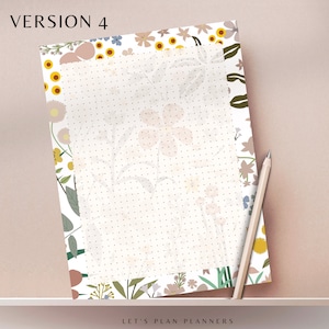 May include: A white planner page with a dotted grid pattern. The page is surrounded by a floral border with pink, yellow, and blue flowers on a white background. The text "LET'S PLAN PLANNERS" is at the bottom of the page.