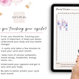 May include: A digital tablet displaying a period tracker with a grid for tracking menstrual cycles. The grid is color-coded with different shades of pink, blue, and purple. The tablet is on a white surface with a hand holding a black stylus.