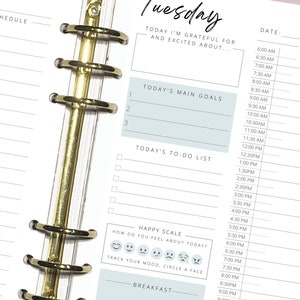 May include: A weekly planner with a blue and white color scheme. The planner has a section for "Today's Main Goals", "Today's To-Do List", and a "Happy Scale" with emojis to track your mood.