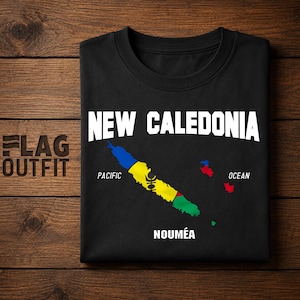 Peut inclure: Un t-shirt noir avec le texte blanc NEW CALEDONIA en haut et NOUMÉA en bas. Au centre, une carte de la Nouvelle-Calédonie colorée en bleu, jaune et vert avec un symbole noir, entourée par les mots PACIFIC et OCEAN imprimés en blanc.