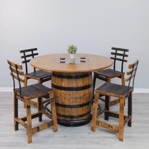 May include: A round wooden table constructed from a repurposed barrel with black metal hoops and a central glass insert, accompanied by four matching high-backed wooden bar stools featuring black metal frames and horizontal slat backrests.
