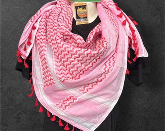 Lenço keffiyeh autêntico, fabricado na Palestina: multicolorido sobre fundo rosa com detalhes em vermelho.
