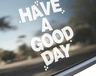 May include: A white vinyl sticker on a car window that says "Have a good day."
