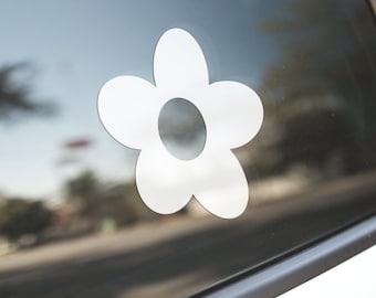 May include: A white flower sticker with a simple design, perfect for adding a touch of whimsy to a car window or any other smooth surface.
